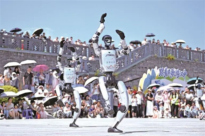 6月20日，市民游客在汉中市天汉楼广场观看机器人表演。