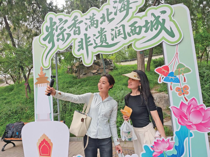 6月19日，北海公园，“粽香·雅趣·乐西城”端午节系列文化活动上，市民在国风展板前打卡。　新京报记者　薛珺　摄