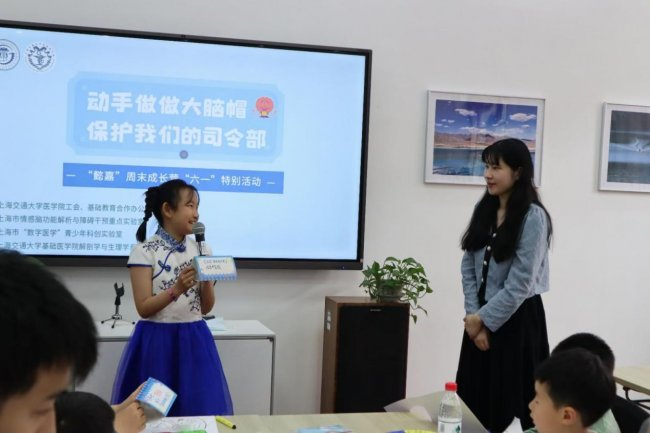 图6:樊盼玉作为志愿者,在“懿嘉”周末成长营向小朋友科普大脑知识,指导制作大脑帽