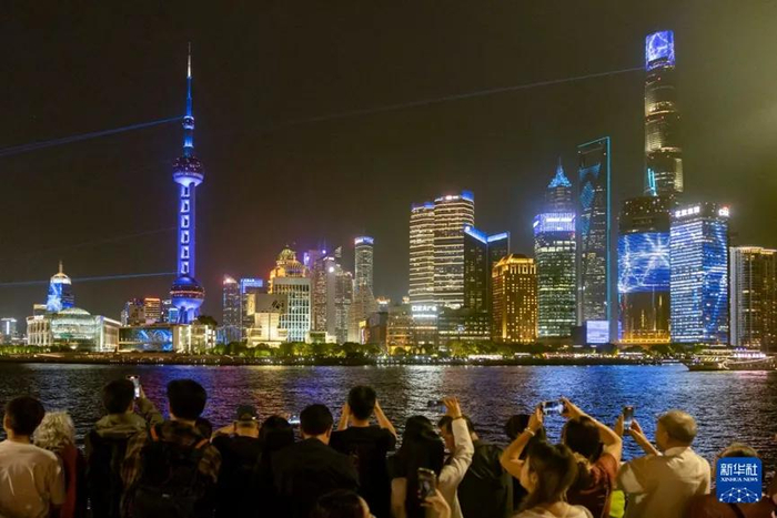 人们在上海外滩拍摄对岸陆家嘴庆祝浦东开发开放35周年光影秀（2025年4月17日摄）。新华社记者 王翔 摄