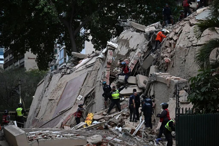 24日，委内瑞拉发生两次强烈地震，救援人员在加拉加斯一栋倒塌的建筑物内搜寻遇难者。