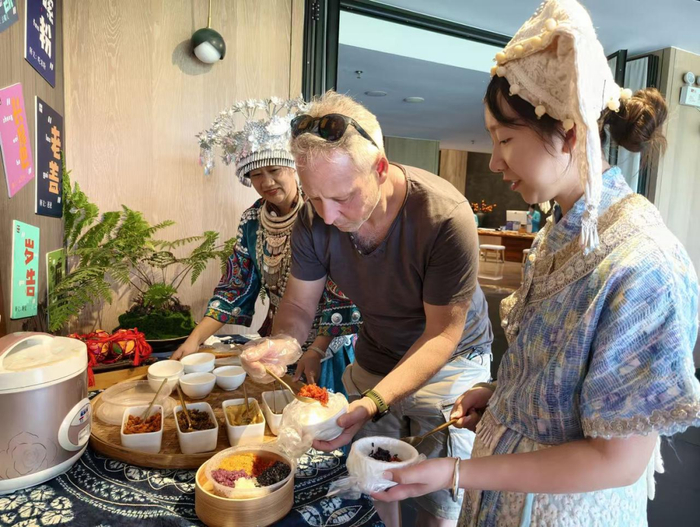 外国游客在广西品尝糯米饭