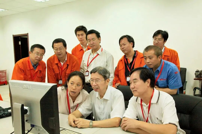 2010年8月，陈俊武（前排中）在神华集团包头煤化工有限公司百万吨级工业示范装置现场与研究、设计人员讨论现场运行数据