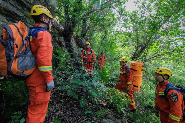 消防员在山间空地确认营救方案。新京报记者 王子诚 摄