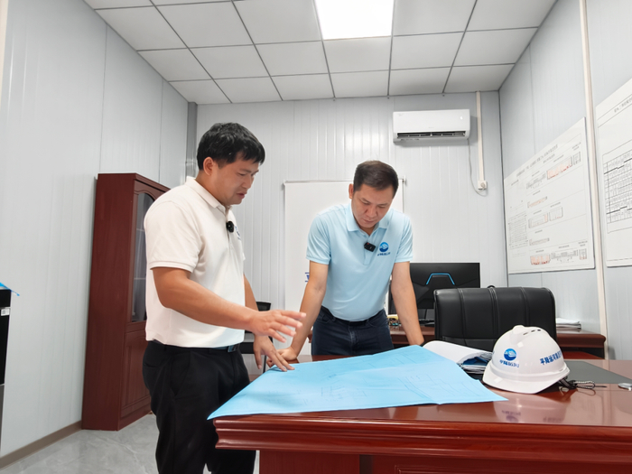 ▲潘剑和陆冠臻一起研究施工图纸