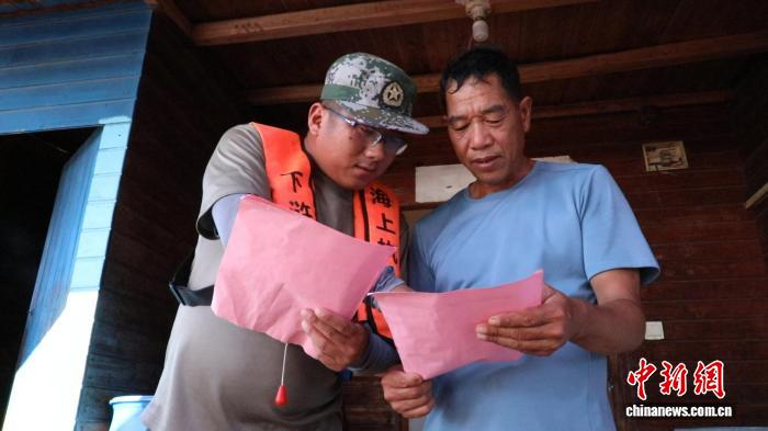 在宁德市霞浦县下浒镇，工作人员登上渔排向养殖户宣传台风防御要求。陈绘羽 摄