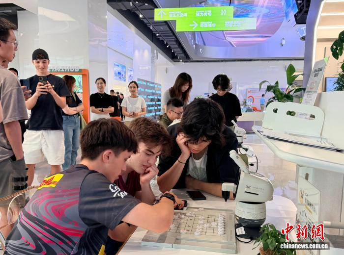 7月9日，在上海张江人工智能创新小镇的AI应用商店，参观者在体验AI下棋机器人。中新社记者 郑莹莹 摄