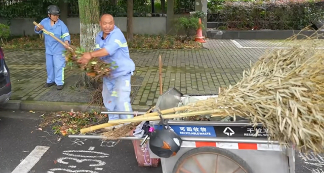 张杰武夫妇清扫道路。 闵行区绿化市容局供图