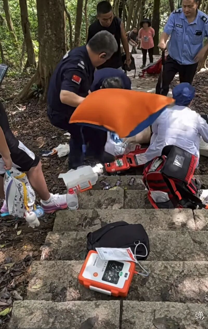 登山道上，医护人员正在对男子实施抢救。