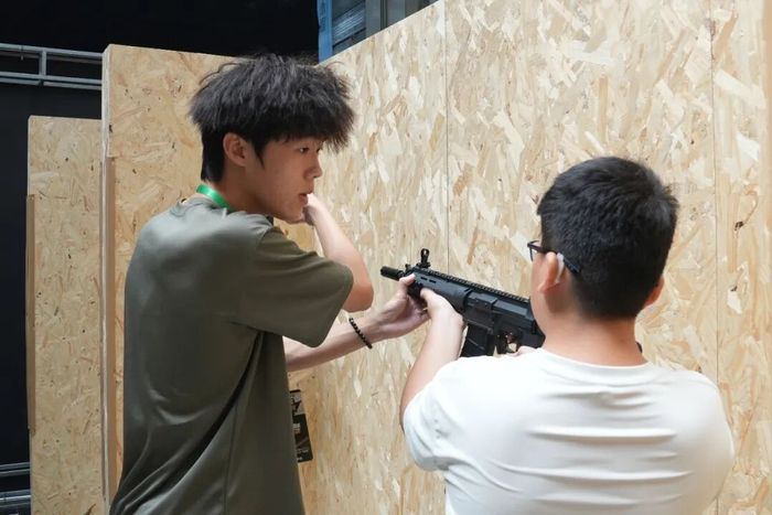 工作人员在给凡凡（右）讲解射击要领