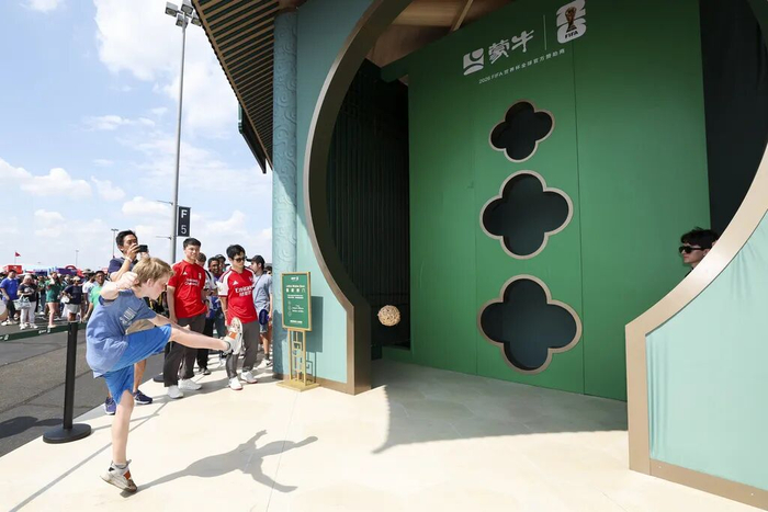 外国小球迷在纽约新泽西体育场蒙牛国风展馆体验蹴鞠