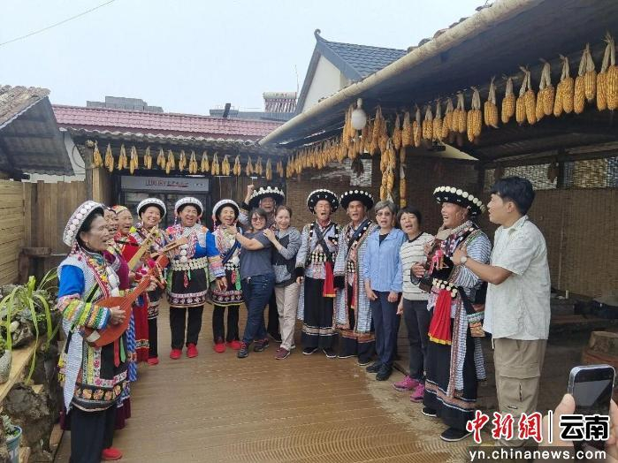 泸水阳坡农家乐里，傈僳族歌舞表演者们与游客合影留念。图源：怒江州委宣传部