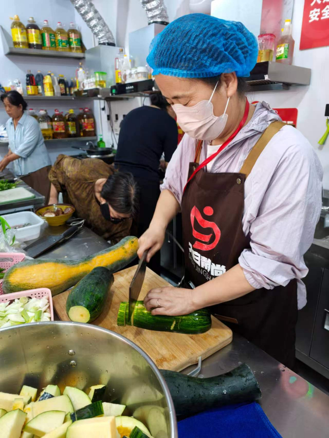 图为患者家属在爱心厨房里备菜做饭