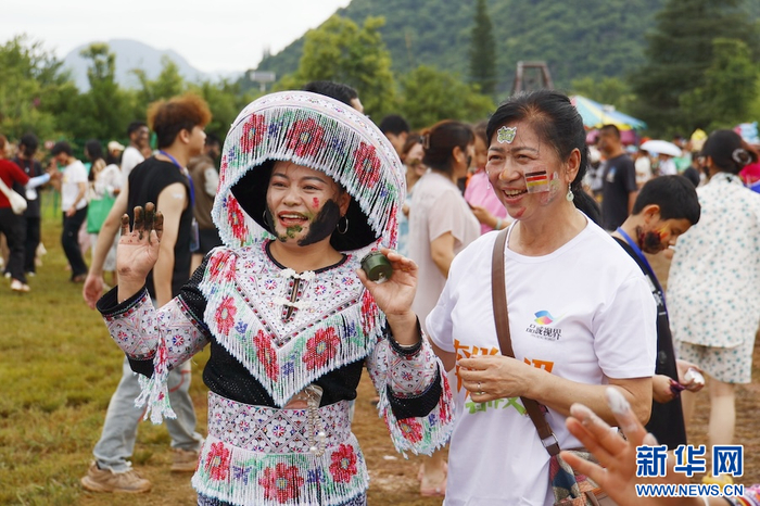 游客与当地群众合影留念（7月18日摄）。新华网发（刘云 摄）