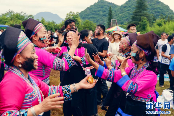 参与活动的群众互相抹花脸（7月18日摄）。新华网发（刘云 摄）