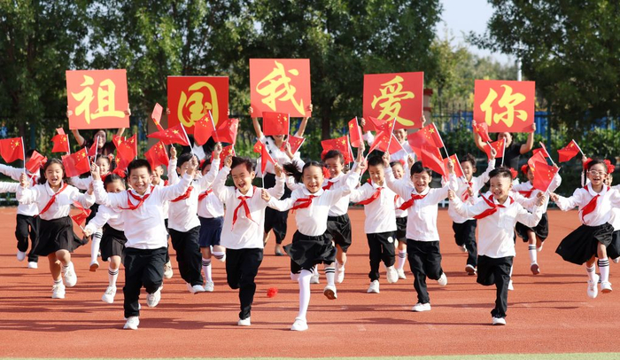  2024年9月29日，山东省临沂市郯城县第一实验小学学生手持国旗快乐奔跑，喜迎国庆节的到来。新华社发（张春雷摄）