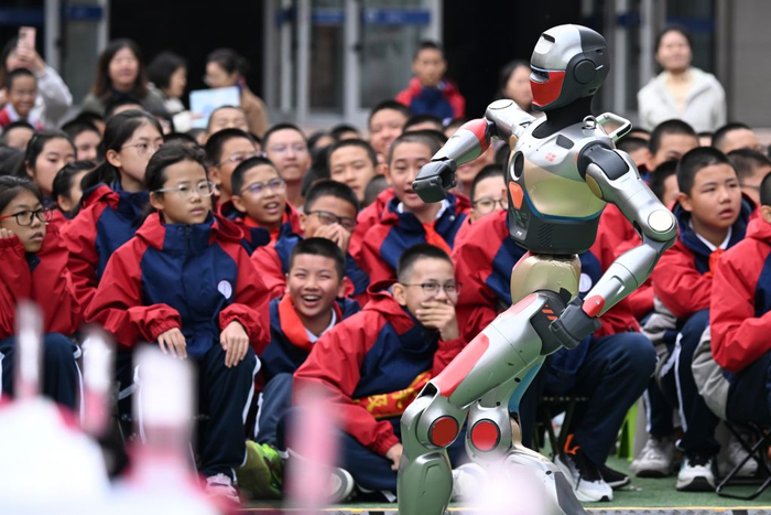 2025年10月13日，新疆生产建设兵团第一中学学生在科技节开幕式上观看智能机器人跳舞。新华社记者 王菲 摄