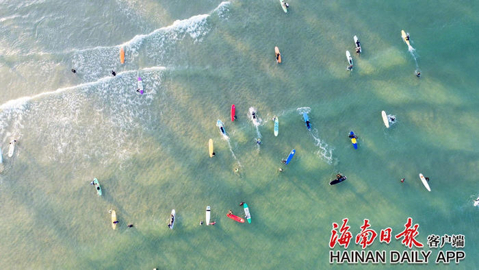 ​万宁日月湾，游客们学习冲浪，享受着惬意的海边生活。海南日报全媒体记者 袁琛 摄