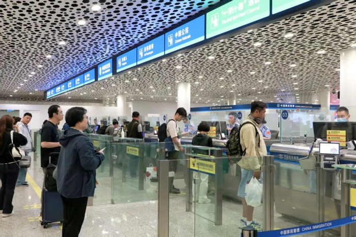 深圳边检总站深圳机场边检站民警为入境旅客办理通关手续。（曾辉 摄）