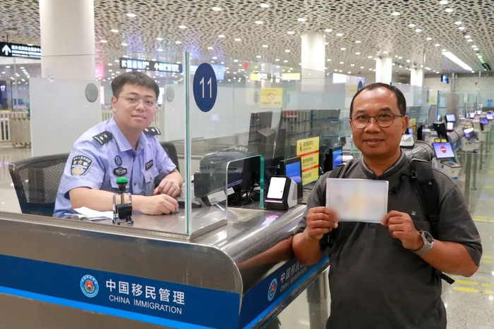 深圳边检总站深圳机场边检站民警为外籍旅客办理240小时过境免签手续。（曾辉 摄）