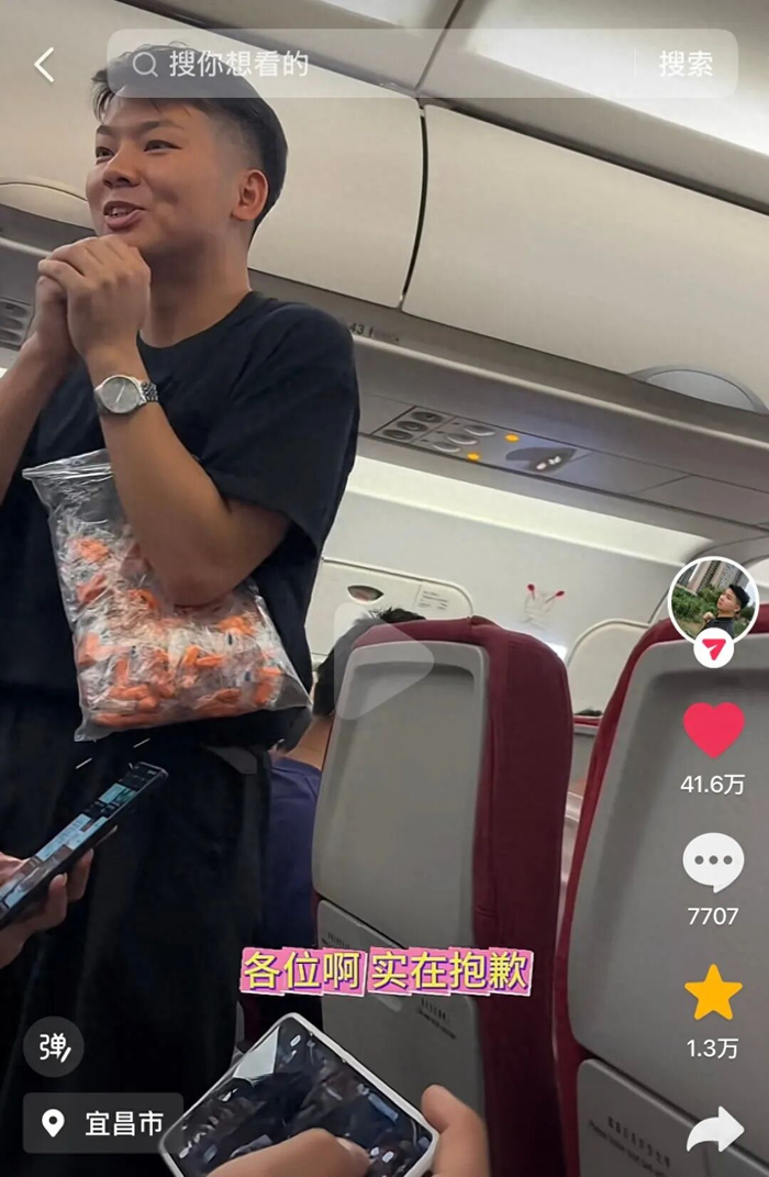 陈先生在机舱内分发耳塞。图/视频截图