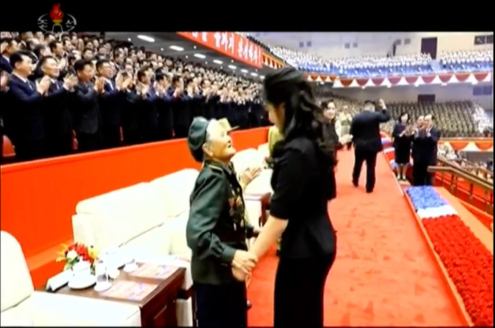 7月27日，金正恩携妻女出席祖国解放战争胜利73周年纪念演出。演出前，金正恩的女儿和老兵代表握手、拥抱致意。图/朝鲜中央电视台报道截图。