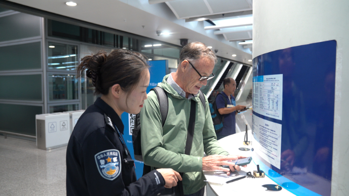 昆明长水国际机场，民警帮助旅客填写入境资料。徐彦 毕琦媛 摄