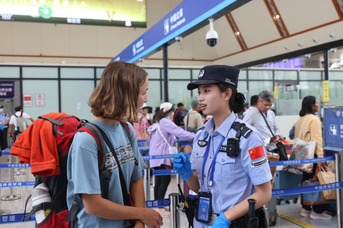 磨憨移民管理警察在磨憨铁路口岸现场接受外国籍旅客的咨询。黄远飞 摄