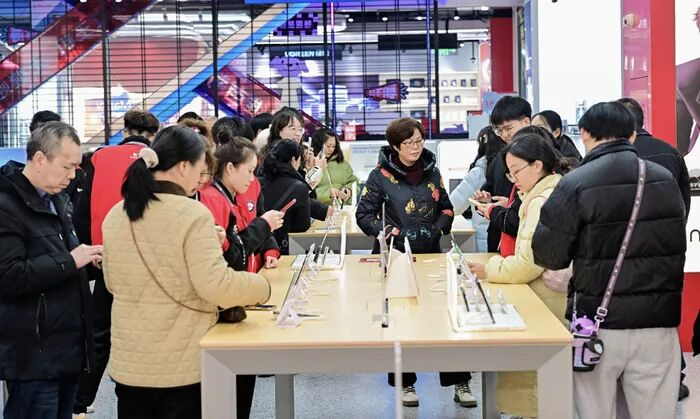 重庆京东MALL内消费者选购手机 图源：新华社