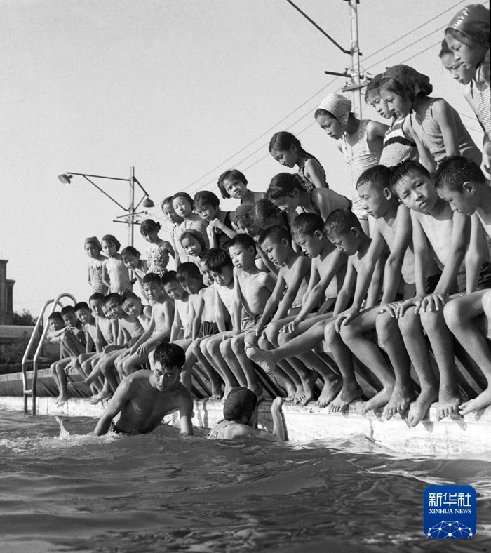 1961年，游泳训练班的孩子们在教练员帮助下学游泳。新华社记者 孙永盛 摄