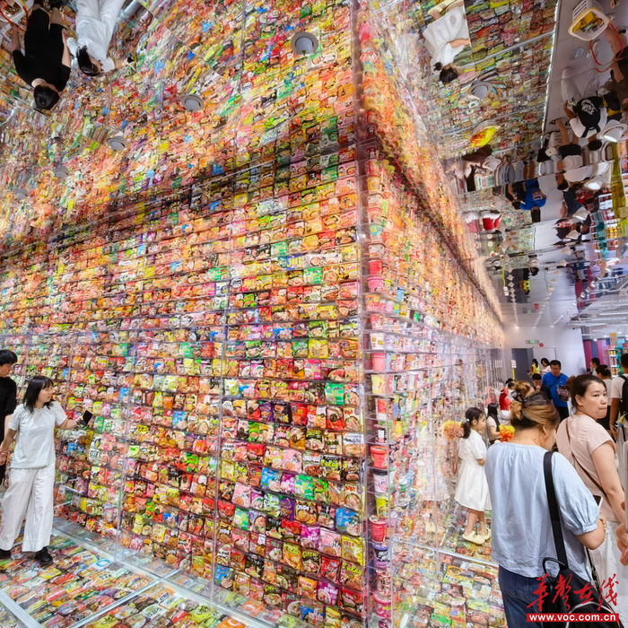 零食王国泡面墙前,打卡拍照、选购的游客及市民络绎不绝。 邹伟瑜 摄