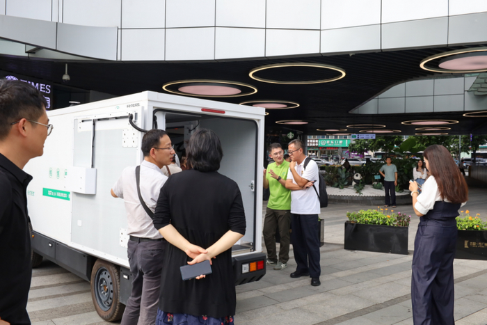 图/参会嘉宾观摩新能源物流车与无人车