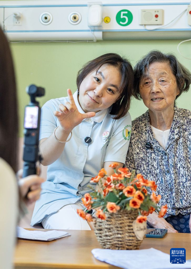 8月17日，沈婉婷（左）在和一位老人录制短视频作品《湖州话等级考试》。 新华社发（伊凡 摄）