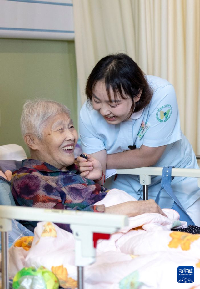 8月11日，浙江省湖州市蜀山养护院内，沈婉婷（右）和一位老人拍摄视频。 新华社发（伊凡 摄）