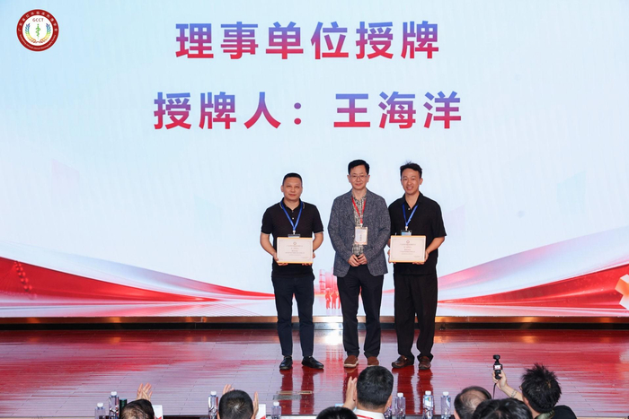 △广东省红外临床热像学会副会长王海洋教授（中）为骏丰科技代表（右）授牌