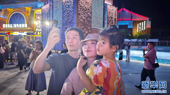游客阿福和家人在快闪活动现场，享受音乐带来的快乐。新华网 刘默涵 摄