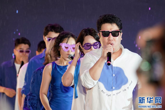 参演青年在雨中热情开唱。新华网 蒋巧玲 摄