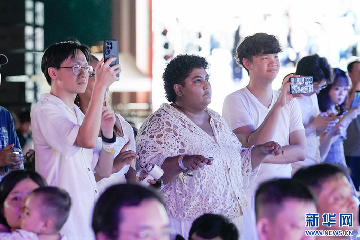 在台下观演的乐团成员拿起手机记录精彩时刻。新华网 蒋巧玲 摄