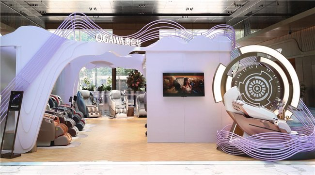 图1：奥佳华西安SKP 30周年巡回展总览，紫色与灰色主色调的沉浸式展馆，陈列多款旗舰按摩椅产品