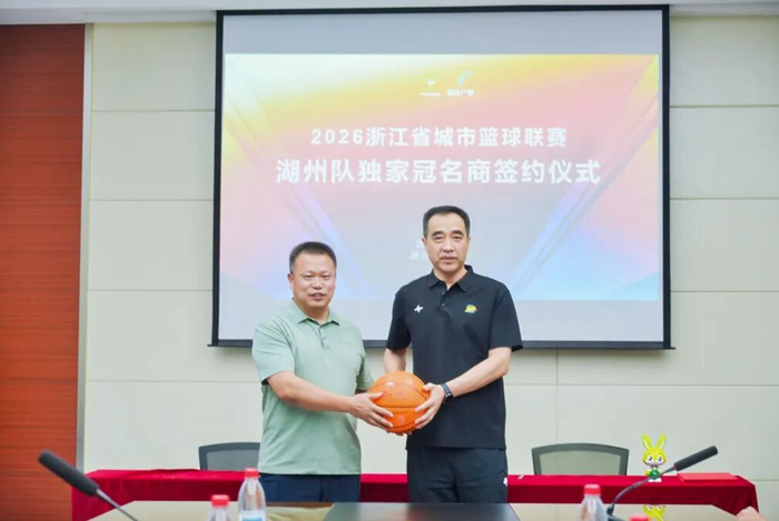 ▲湖州队副领队林明（右）向德华兔宝宝装饰新材股份有限公司副总经理徐伟达（左）赠送定制篮球。