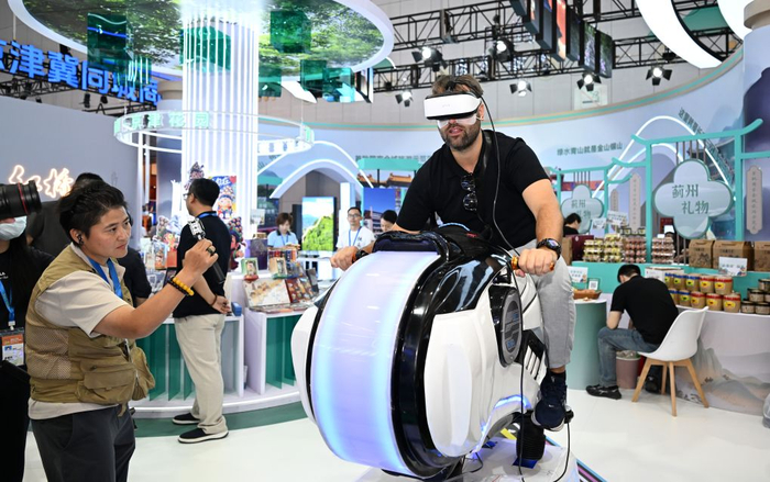  9月3日，一名来自意大利的参观者在博览会河海津韵天津展区体验VR动感摩托。新华社记者 孙凡越 摄