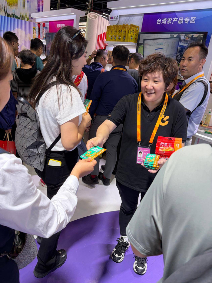 图：呷哺集团工作人员向观众发放试吃产品