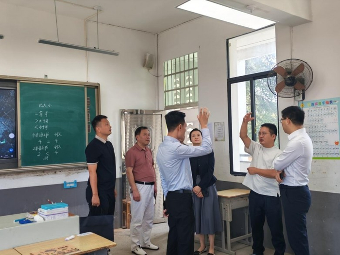 图2 调研组在益丰小学察看“学校明亮工程”新安装的照明设备使用情况