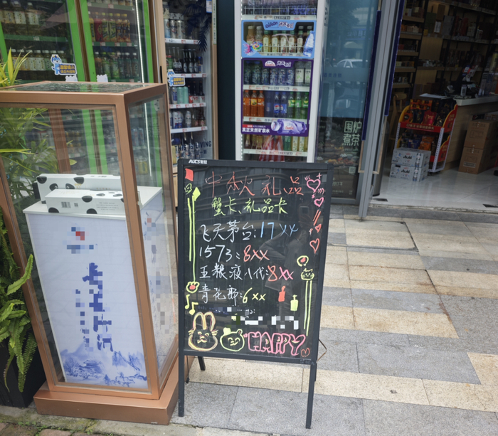 ▲酒类连锁门店门口放置的中秋礼品手写黑板。李海颜/摄