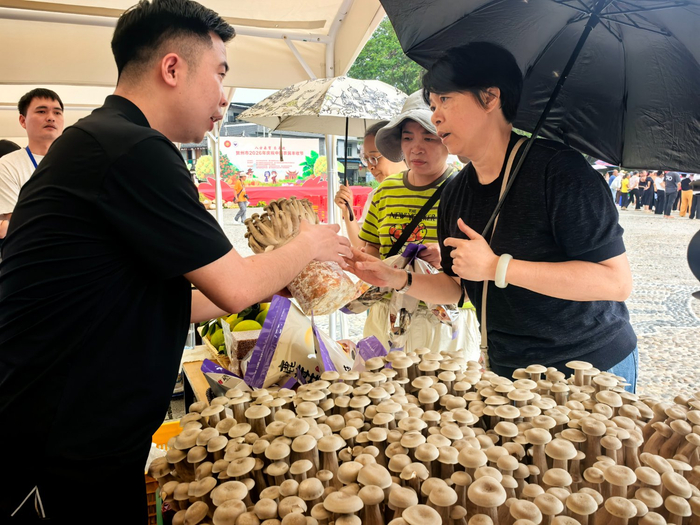 图为现场展销的农产品吸引了众多消费者