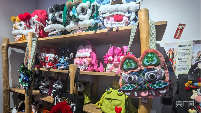 醒狮玩偶、刺绣虎头包摆放在展架上（央广网记者 吴佳仪 摄）