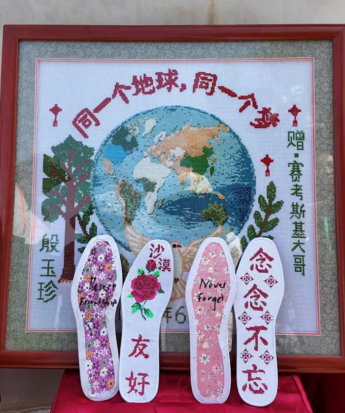  8月25日，殷玉珍为“赛考斯”送上亲手缝制的鞋垫和十字绣。人民日报记者 余星馨 摄