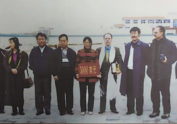 这是“赛考斯”（右三）与殷玉珍（中）于2000年春在捐赠仪式上的合影（资料照片）。