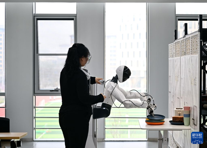 中国雄安集团数字城市科技有限公司具身智能训练场的工作人员在训练机器人（2026年3月26日摄）。新华社记者 牟宇 摄
