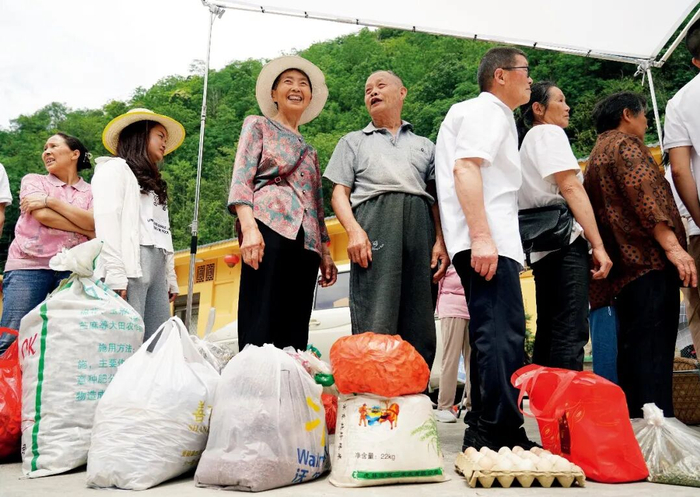 2025年6月24日，在陕西安康市岚皋县孟石岭镇电商直播基地，群众排队由村干部与电商主播一起帮助售卖山货。图/新华